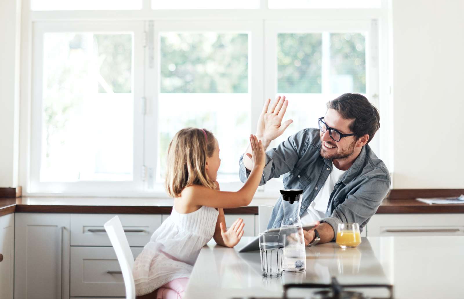Shot of an adorable little girl using a digital tablet with her father at home